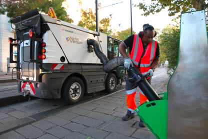 The BOB glass container is emptied using a vacuum sweeper. A hinged door provides access to the glass for vacuuming. Two technical staff from Nantes Métropole vacuum up glass bottles for recycling.