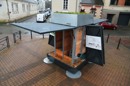 Composteur collectif EKOVORE installé place Grégoire Bordillon à Angers. Les deux hayons du composteur sont ouverts et dévoilent les silo d'apport des biodéchets à l'intérieur du composteur.