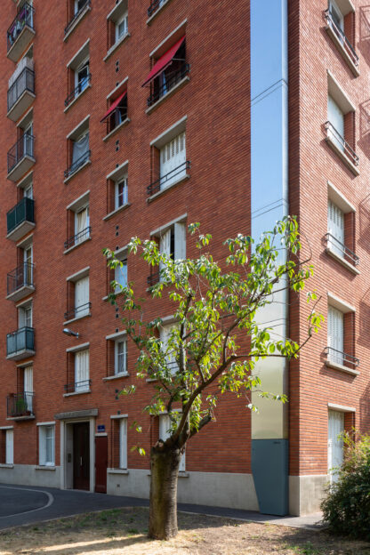 Reënstok est une colonne-réservoir d'eau pluviale greffée, ici, à la façade d'un immeuble localisé rue Louis Blanc à Paris