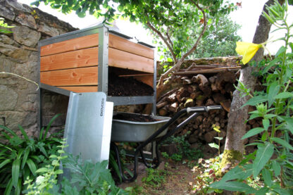 Composteur individuel Ekovore de 300 L installé dans un jardin-potager et pouvant accueillir une brouette en partie basse pour faciliter son vidage