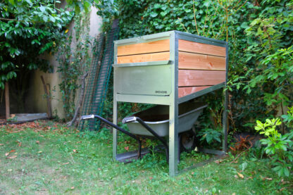 Composteur individuel Ekovore de 300 L installé dans un jardin-potager et pouvant accueillir une brouette en partie basse pour faciliter son vidage
