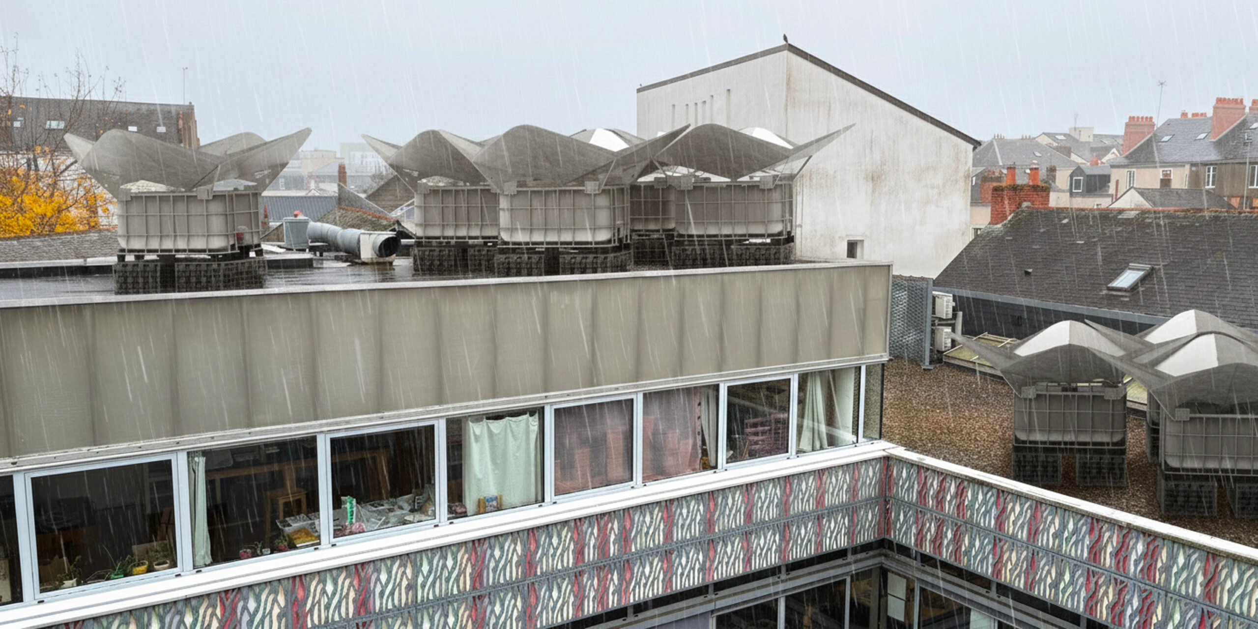 Collecteur d'eau Rosiluv posé sur une toiture-terrasse sous la pluie pour récupérer l’eau pluviale.