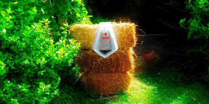 Uritonnoir installé sur balle de paille au fond d'un jardin