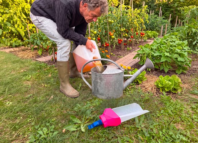 Jardinier utilisant de l’urine diluée pour fertiliser son potager avec SUPERFERTIL